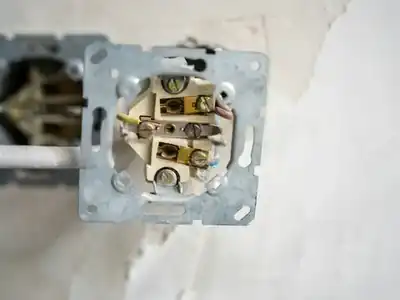 Outlet pulled from the wall showing its wiring