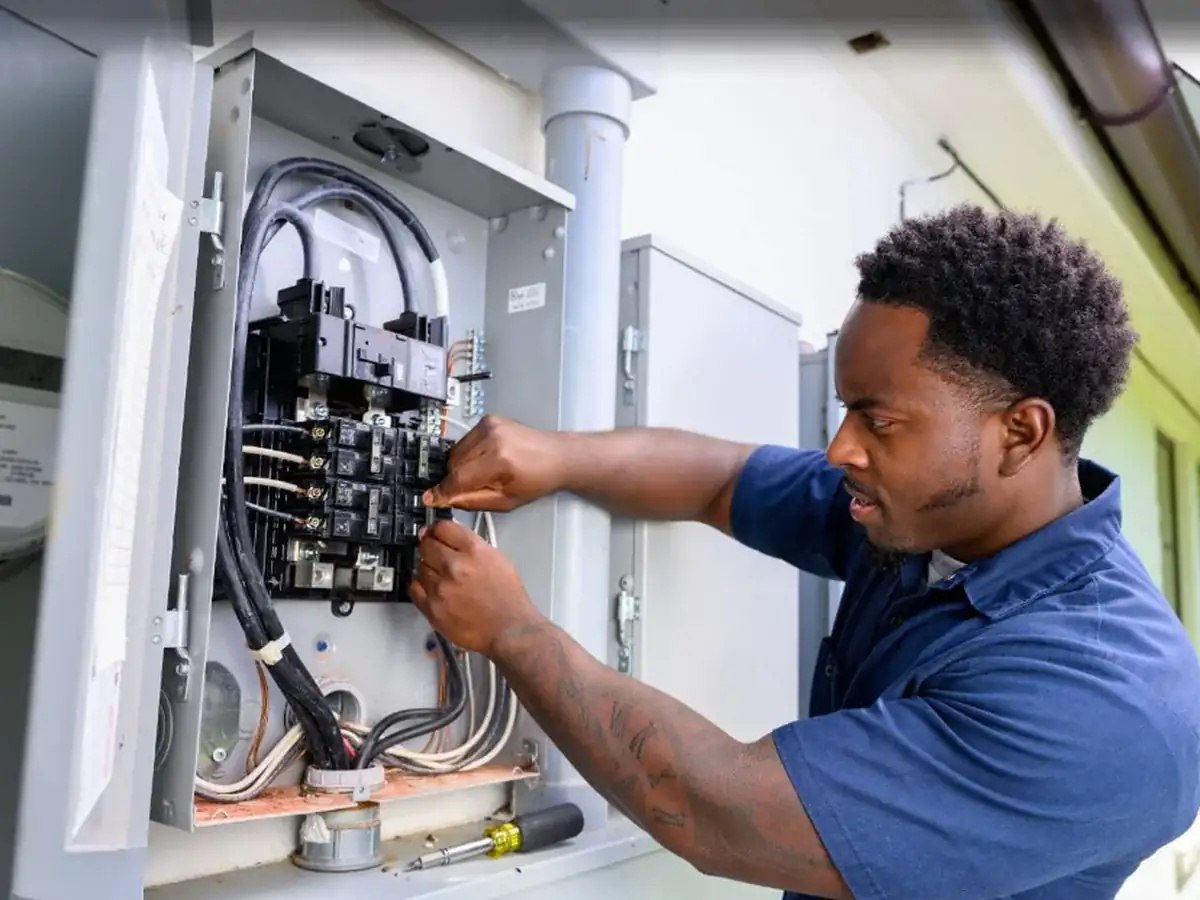 Electrician working inside an electrical panel