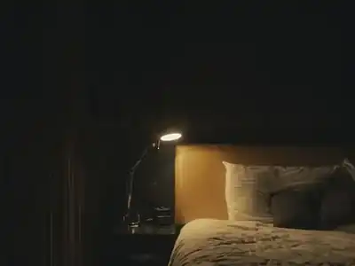 Bedroom lit by a bedside lamp