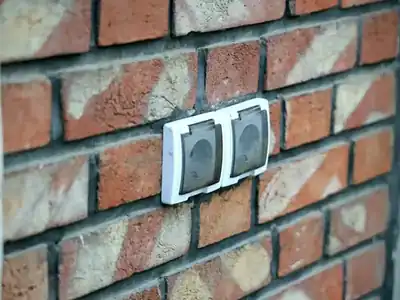 Outdoor outlets with weatherproof covers on a brick wall